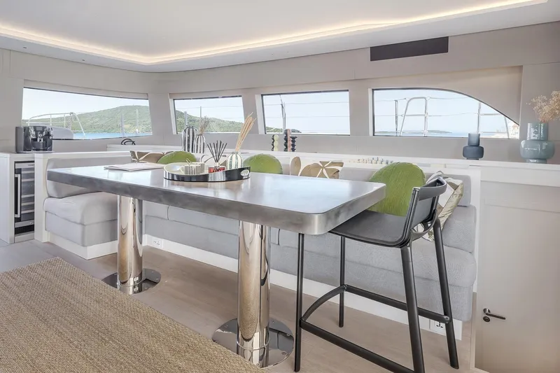 Big Picture Yacht Photos Pics Luxurious interior of 2024 Lagoon SIXTY 5 yacht with modern dining area and scenic windows.