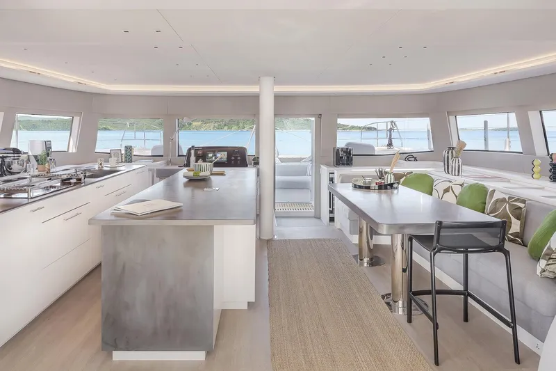 Big Picture Yacht Photos Pics Luxurious interior of 2024 Lagoon SIXTY 5 yacht with modern kitchen and dining area.