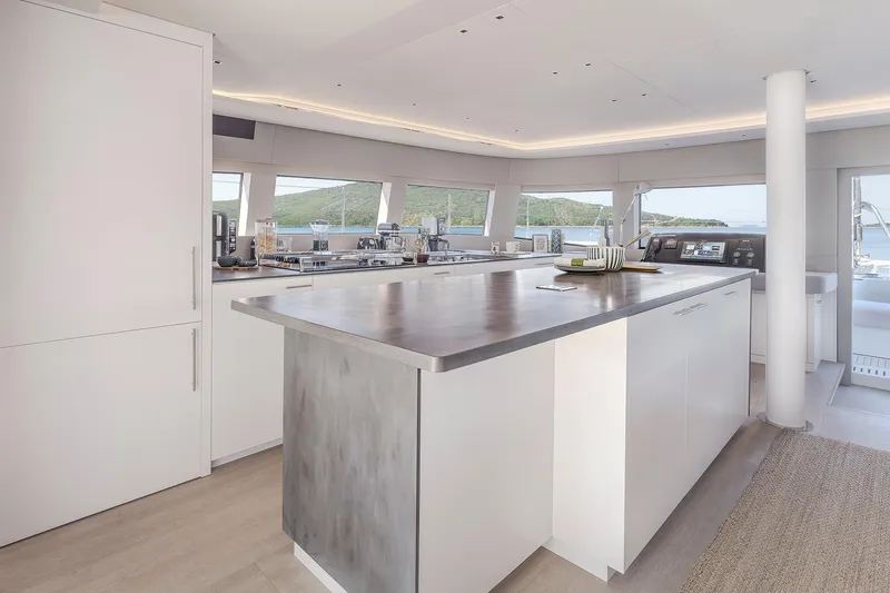 Big Picture Yacht Photos Pics Luxurious interior of 2024 Lagoon SIXTY 5 yacht with modern kitchen and panoramic windows.