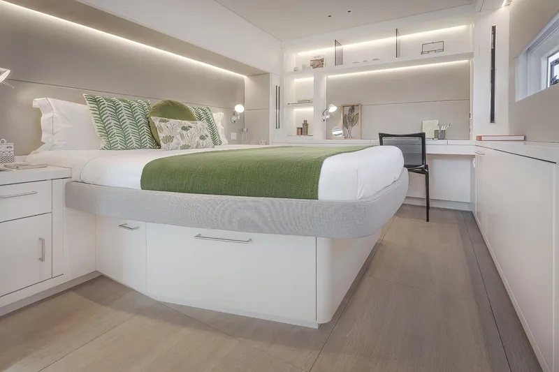 Big Picture Yacht Photos Pics Luxurious bedroom interior of 2024 Lagoon SIXTY 5 yacht with modern design and green accents.