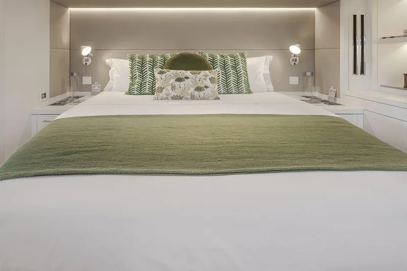 Big Picture Yacht Photos Pics Luxurious bedroom interior of 2024 Lagoon SIXTY 5 yacht with green accents.