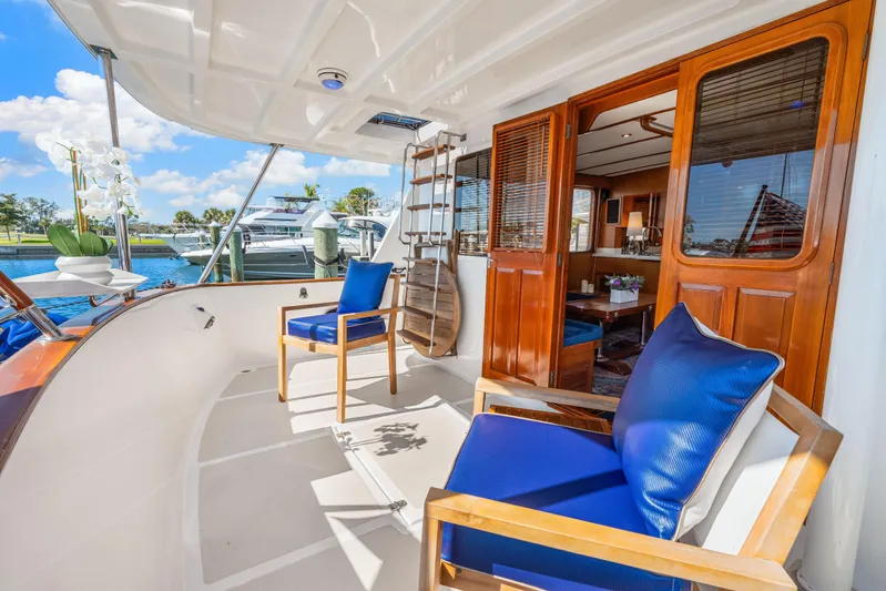 Sugar Yacht Photos Pics 2008 DeFever 52 Euro yacht deck with blue cushioned chairs and wooden interior.