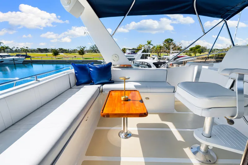 Sugar Yacht Photos Pics Luxurious 2008 DeFever 52 Euro yacht deck with seating, table, and blue cushions.