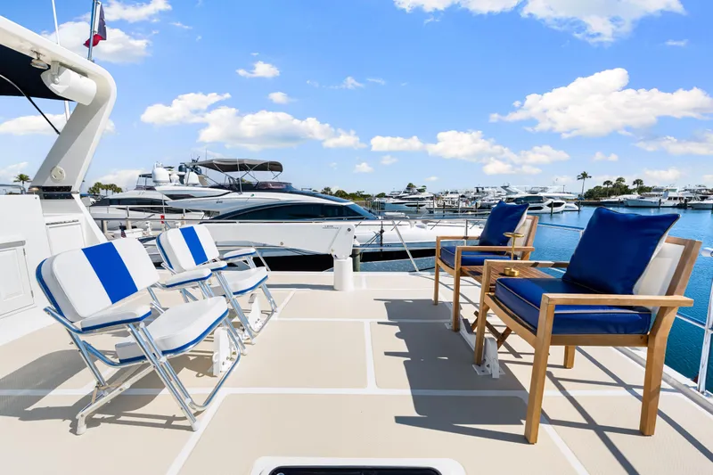 Sugar Yacht Photos Pics Deck of 2008 DeFever 52 Euro yacht with blue and white seating, marina view.