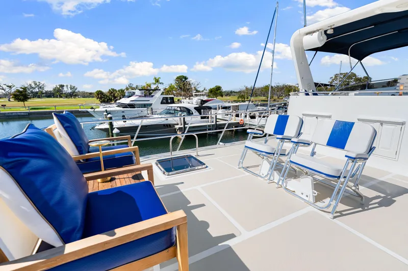 Sugar Yacht Photos Pics Deck of 2008 DeFever 52 Euro yacht with blue seating, docked in marina.