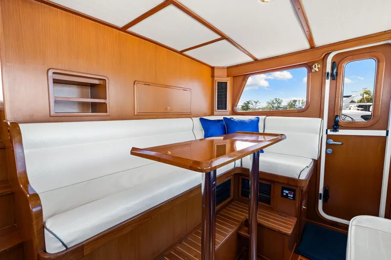 Sugar Yacht Photos Pics Luxurious interior of 2008 DeFever 52 Euro yacht with wood finish and white seating.