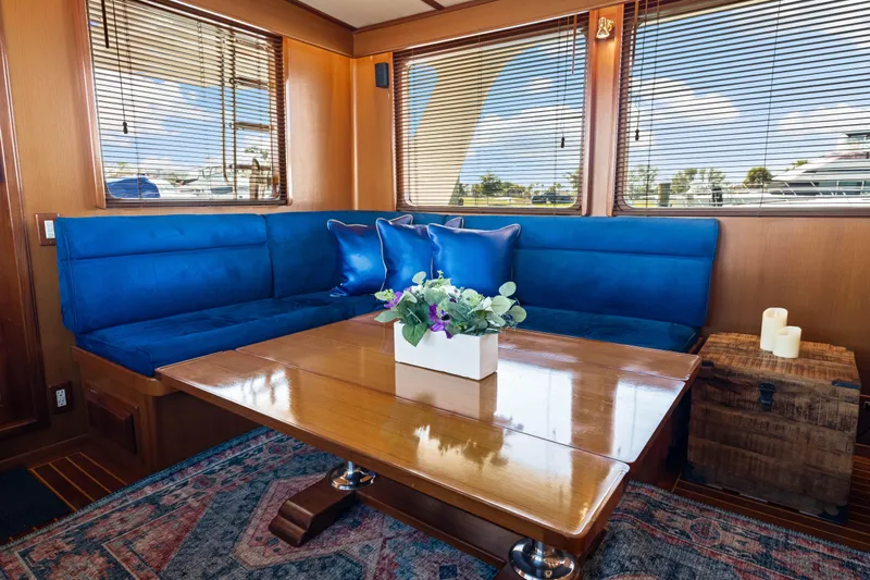 Sugar Yacht Photos Pics Luxurious 2008 DeFever 52 Euro yacht interior with blue seating, wooden table, and decorative accents.