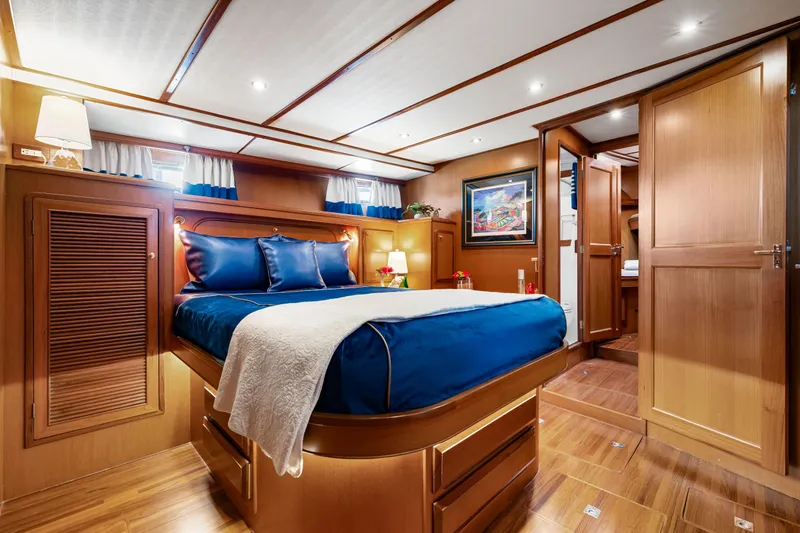 Sugar Yacht Photos Pics Luxurious 2008 DeFever 52 Euro yacht bedroom with elegant wood finish and blue bedding.