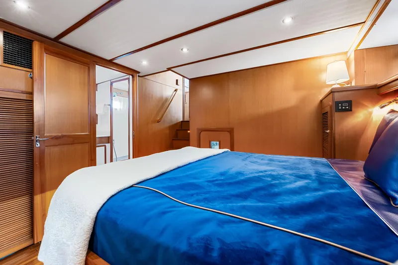 Sugar Yacht Photos Pics Luxurious cabin interior of 2008 DeFever 52 Euro yacht with blue bedding and wooden accents.