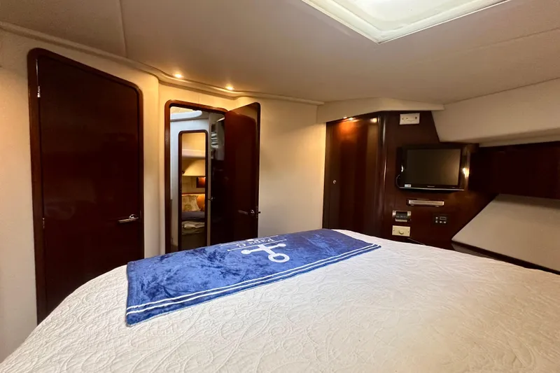  Yacht Photos Pics Luxurious interior of 2009 Sea Ray 44 Sedan Bridge yacht bedroom with TV and elegant wood finish.