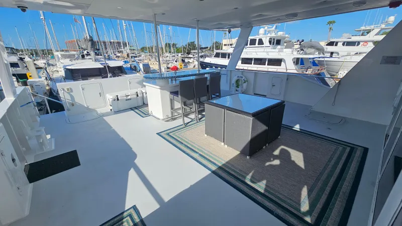 Island Soul Yacht Photos Pics Spacious deck of 2009 Custom Flybridge Motoryacht in marina, featuring outdoor seating and table.
