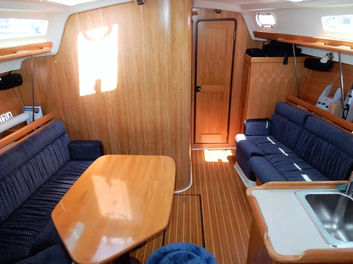 Milky Way Yacht Photos Pics Interior of 2004 Catalina 350 sailboat with wooden furnishings and blue upholstered seating.