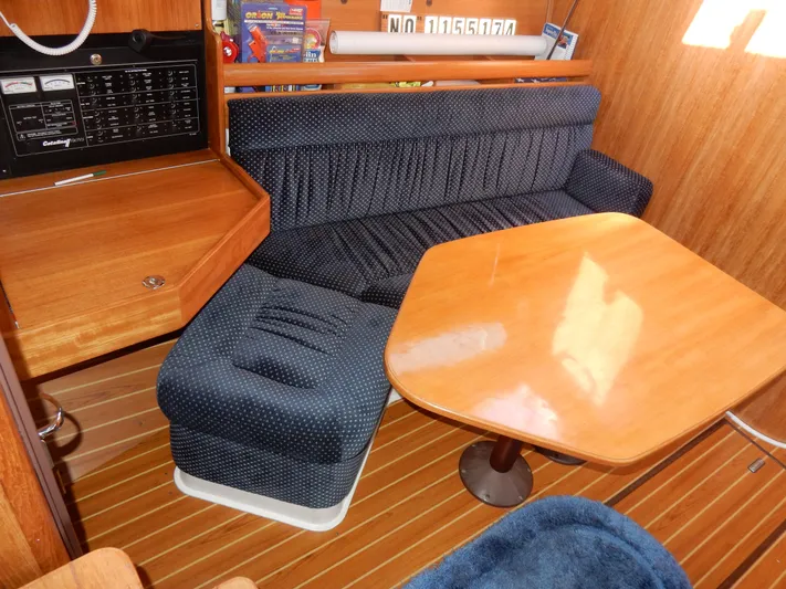 Milky Way Yacht Photos Pics Interior of 2004 Catalina 350 sailboat with wooden table and blue upholstered seating.