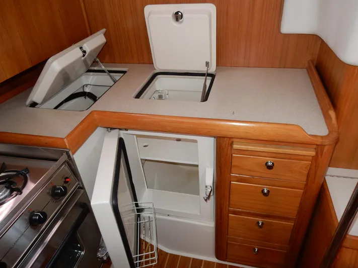 Milky Way Yacht Photos Pics 2004 Catalina 350 yacht kitchen with stove, fridge, and wooden cabinetry.