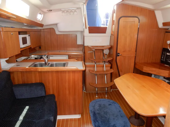 Milky Way Yacht Photos Pics 2004 Catalina 350 yacht interior with wooden cabinetry, kitchen, and dining area.