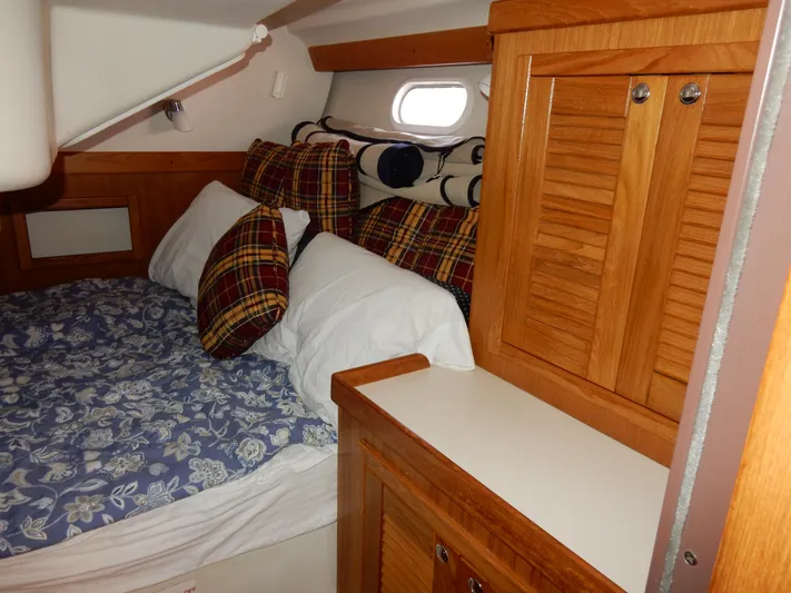 Milky Way Yacht Photos Pics Cozy cabin interior of 2004 Catalina 350 sailboat with plaid pillows and wooden cabinetry.