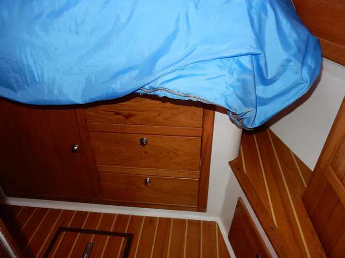 Milky Way Yacht Photos Pics Interior cabin of 2004 Catalina 350 sailboat with wooden drawers and blue bedding.