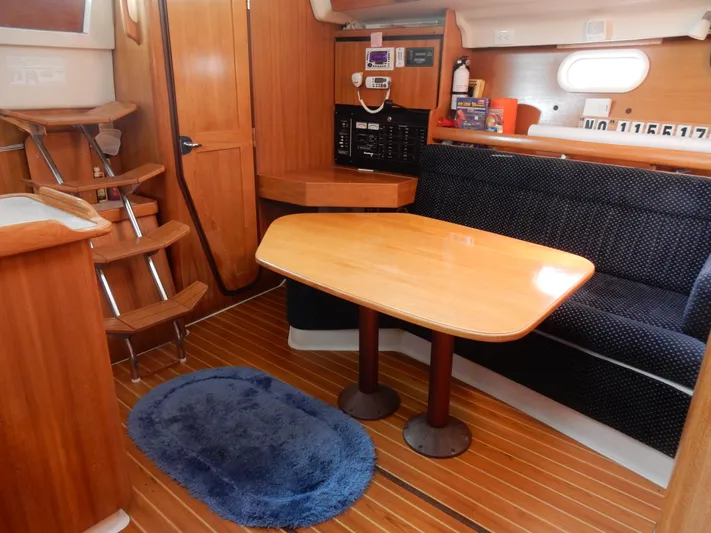 Milky Way Yacht Photos Pics Interior of 2004 Catalina 350 sailboat with wooden table and seating area.