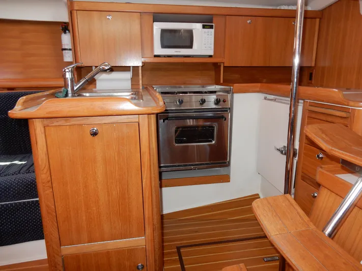 Milky Way Yacht Photos Pics 2004 Catalina 350 yacht kitchen with wood cabinetry, stainless steel oven, and microwave.