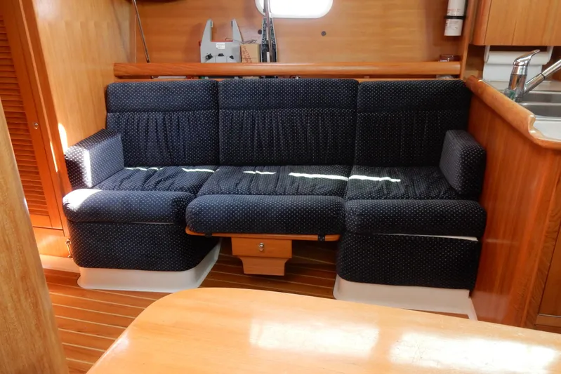 Milky Way Yacht Photos Pics Interior of 2004 Catalina 350 yacht with blue upholstered seating and wooden finishes.