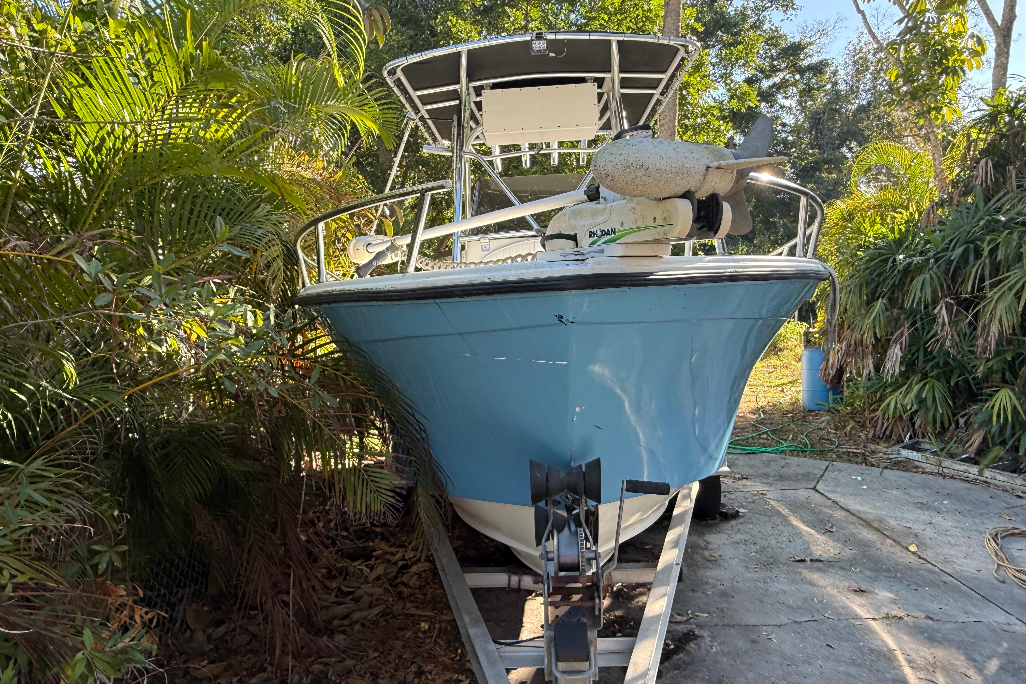 2002 Fishmaster 212 Travis Edition boat on trailer, surrounded by lush greenery.