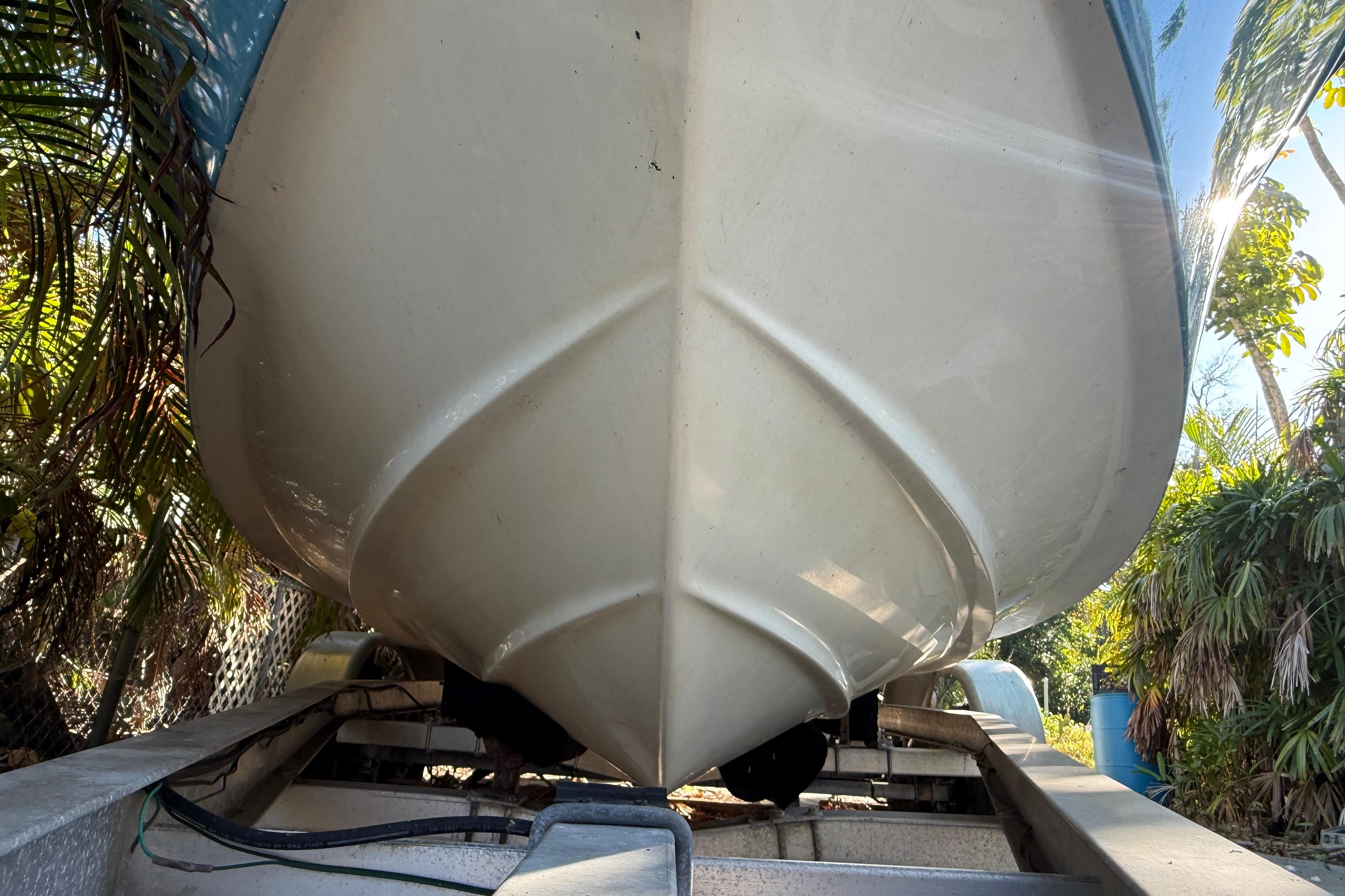 2002 Fishmaster 212 Travis Edition boat on trailer, surrounded by tropical foliage.