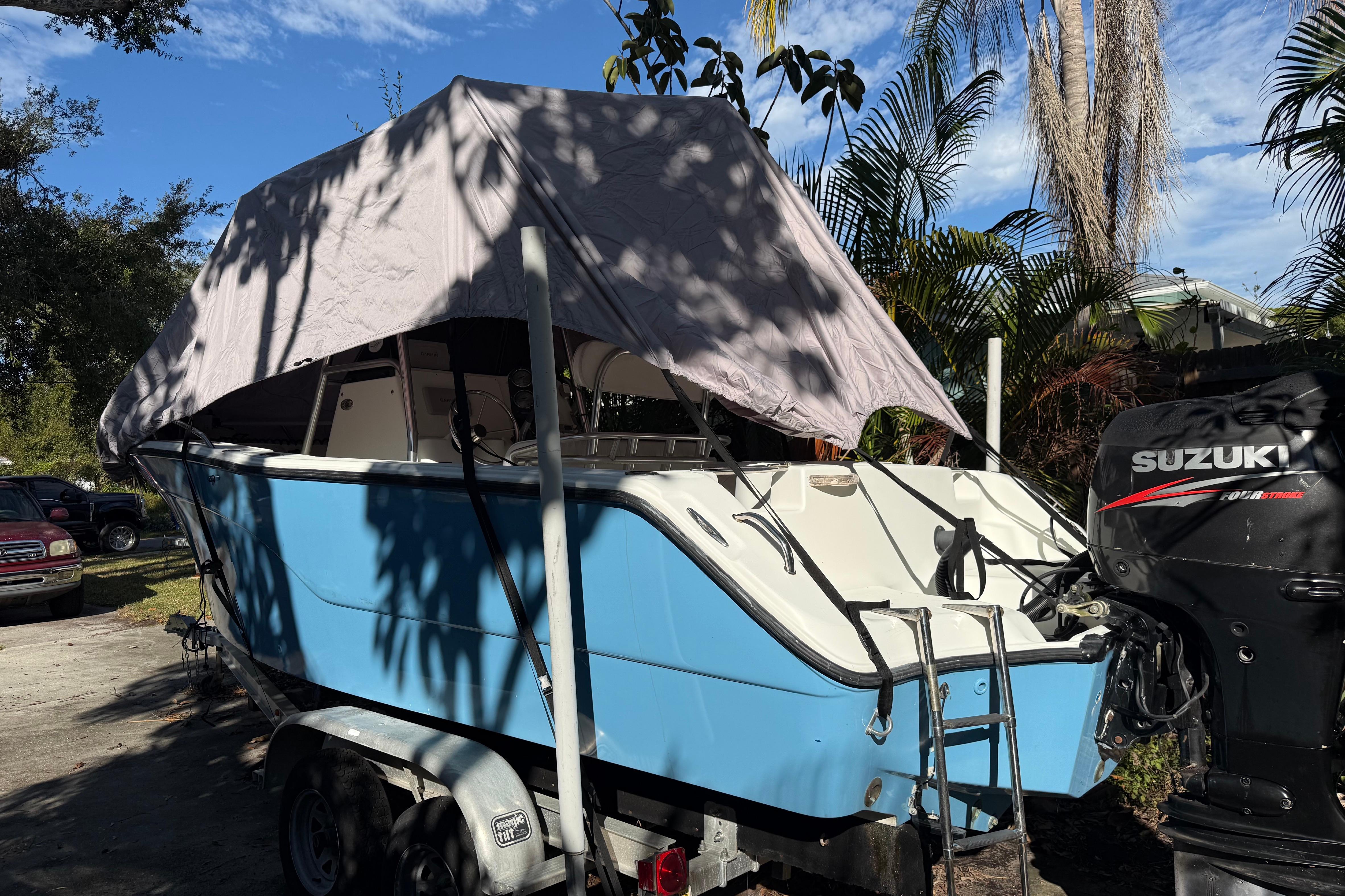 2002 Fishmaster 212 Travis Edition boat with Suzuki outboard motor, parked on trailer.