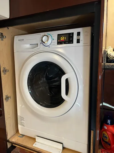 Someday Came Yacht Photos Pics White front-loading washing machine in a wooden cabinet on a 2008 Sea Ray 47 Sedan Bridge.