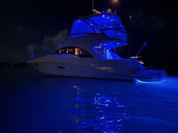 Someday Came Yacht Photos Pics 2008 Sea Ray 47 Sedan Bridge yacht illuminated with blue lights at night.