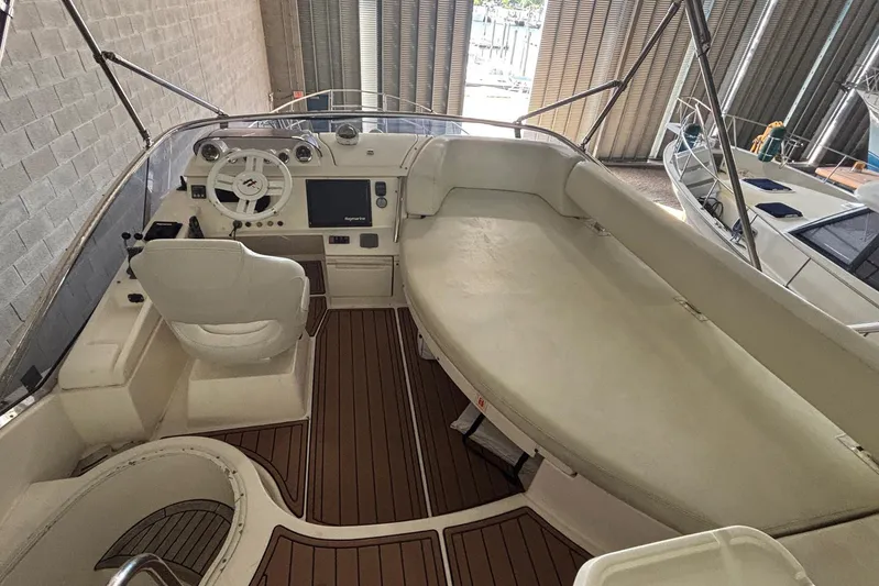 Sylvie Yacht Photos Pics 2009 Azimut 43 yacht interior with helm, seating, and wooden flooring in a marina setting.