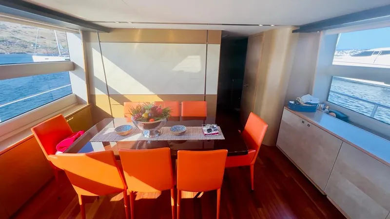  Yacht Photos Pics Interior of a 2015 Princess 82 yacht, dining area with orange chairs.