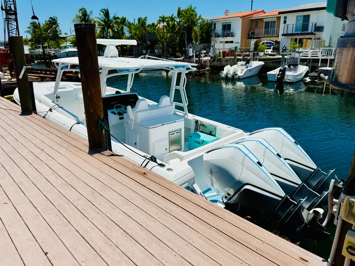  Yacht Photos Pics 2003 Intrepid 377 boat docked by waterfront homes, featuring triple outboard engines.