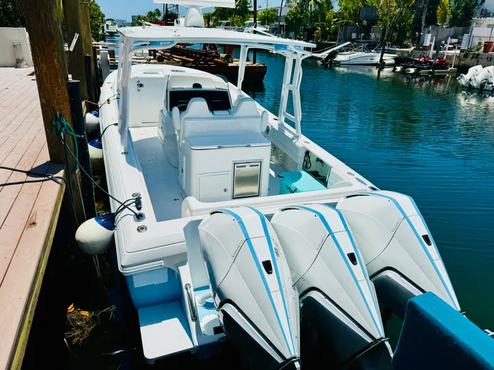  Yacht Photos Pics 2003 Intrepid 377 boat docked with triple outboard engines in a sunny marina.