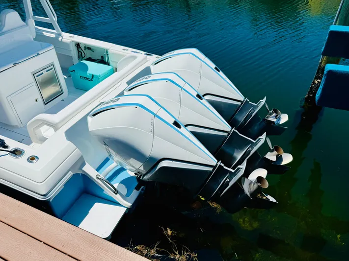  Yacht Photos Pics 2003 Intrepid 377 boat with triple outboard engines docked on calm water.