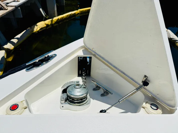  Yacht Photos Pics Anchor compartment of a 2003 Intrepid 377 boat, open with visible chain and winch.