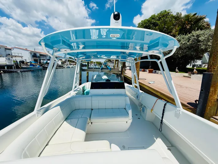  Yacht Photos Pics 2003 Intrepid 377 boat with blue canopy, docked in a scenic waterfront area.
