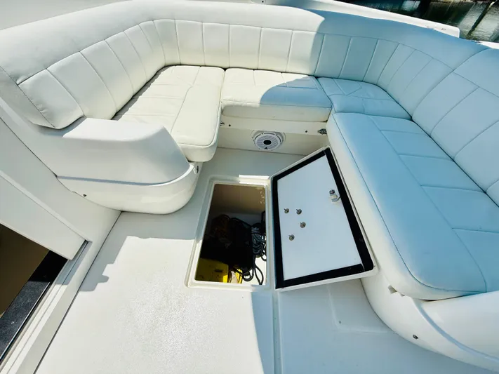  Yacht Photos Pics 2003 Intrepid 377 boat with white cushioned seating and open storage compartment.