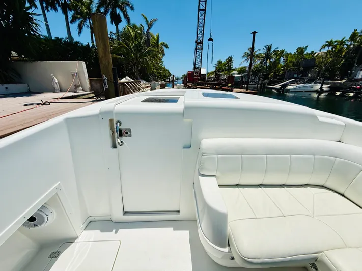  Yacht Photos Pics 2003 Intrepid 377 boat interior with white seating, dockside view, and palm trees.