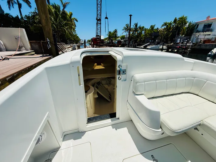  Yacht Photos Pics 2003 Intrepid 377 boat deck with white seating and cabin entrance, docked near palm trees.
