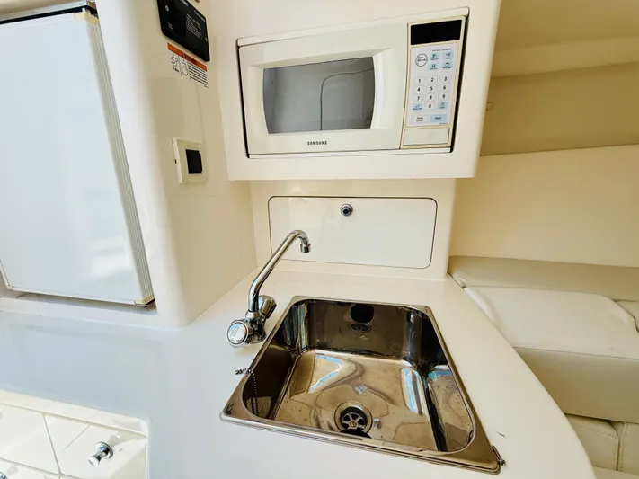  Yacht Photos Pics Compact kitchen area in a 2003 Intrepid 377 boat with sink and microwave.