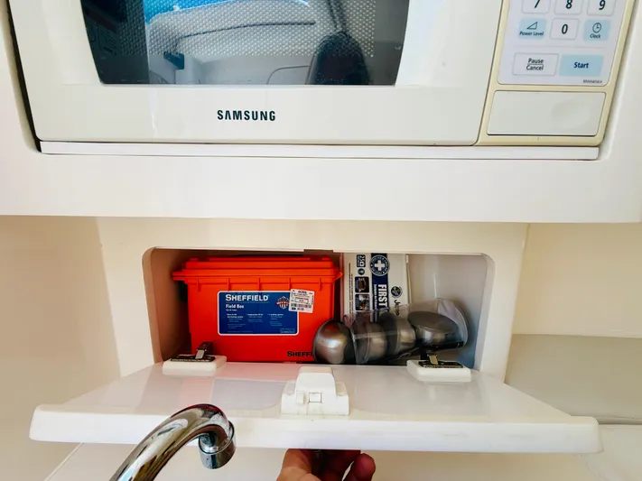  Yacht Photos Pics Storage compartment in a 2003 Intrepid 377 boat, featuring a microwave and safety equipment.