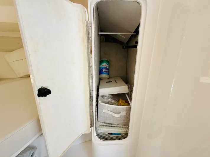  Yacht Photos Pics Storage compartment on a 2003 Intrepid 377 boat, containing cleaning supplies and a basket.