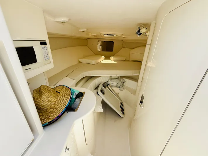  Yacht Photos Pics 2003 Intrepid 377 cabin interior with bed, microwave, and straw hat on counter.
