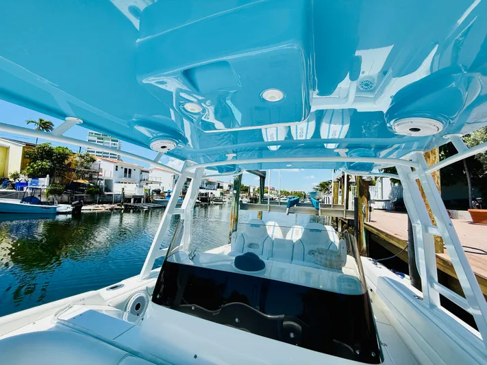  Yacht Photos Pics 2003 Intrepid 377 boat with blue canopy, docked in a sunny marina.