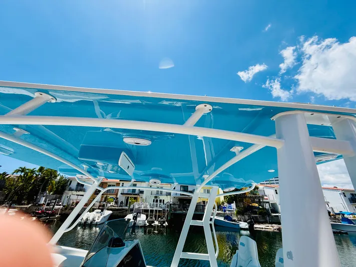  Yacht Photos Pics 2003 Intrepid 377 boat with blue canopy, docked under clear sky.