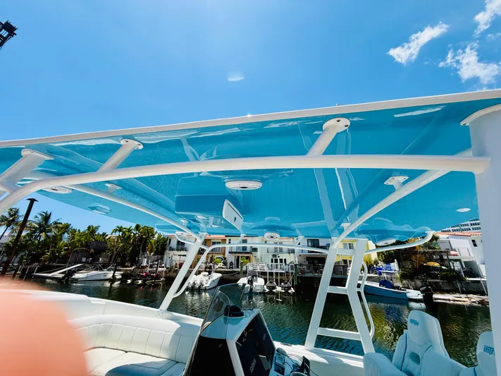  Yacht Photos Pics 2003 Intrepid 377 boat with blue canopy, docked in a sunny marina.