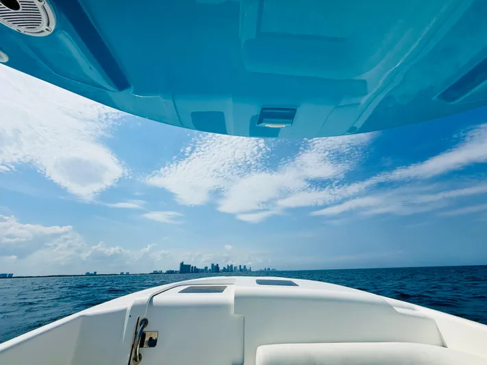  Yacht Photos Pics 2003 Intrepid 377 boat cruising towards city skyline under clear blue sky.