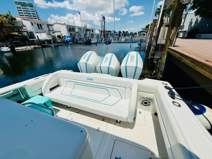  Yacht Photos Pics 2003 Intrepid 377 boat with triple engines docked in a marina under a blue sky.
