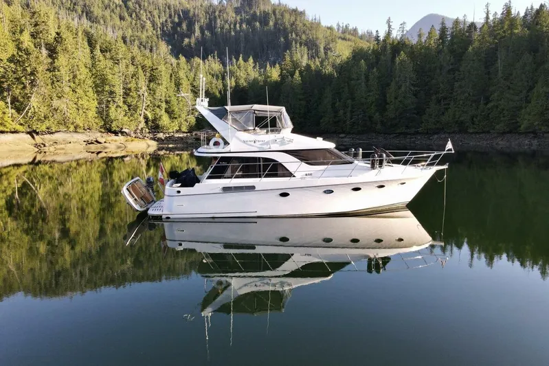  Yacht Photos Pics 1998 Ocean Alexander 420 yacht on tranquil water, surrounded by lush forest.