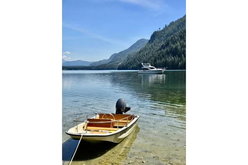  Yacht Photos Pics A 1998 Ocean Alexander 420 yacht on a serene lake with mountains in the background.